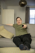 Man sitting on sofa and using remote control