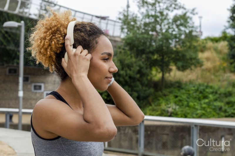 Young woman putting on headphones