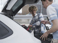 Smiling male couple loading car for trip