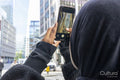 Young woman using phone to take pictures in city