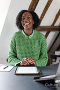 Smiling businesswoman working on digital tablet by desk in office