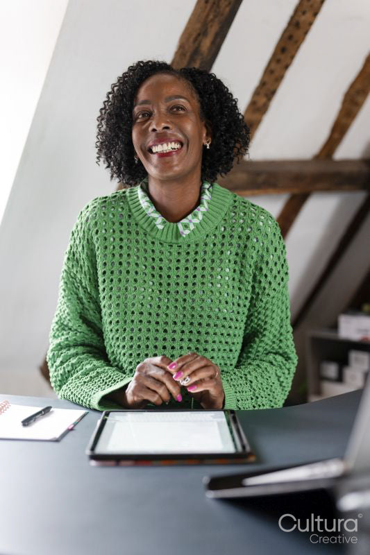 Smiling businesswoman working on digital tablet by desk in office
