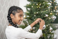 Smiling girl decorating Christmas tree