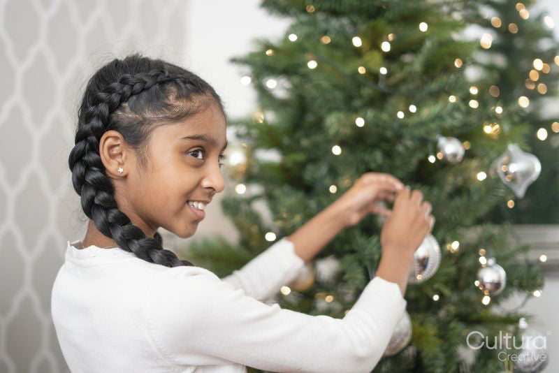 Smiling girl decorating Christmas tree