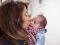 Mother kissing infant daughter