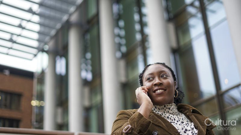 Woman using phone outside office building