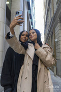 Two young women in city, taking selfie on phone
