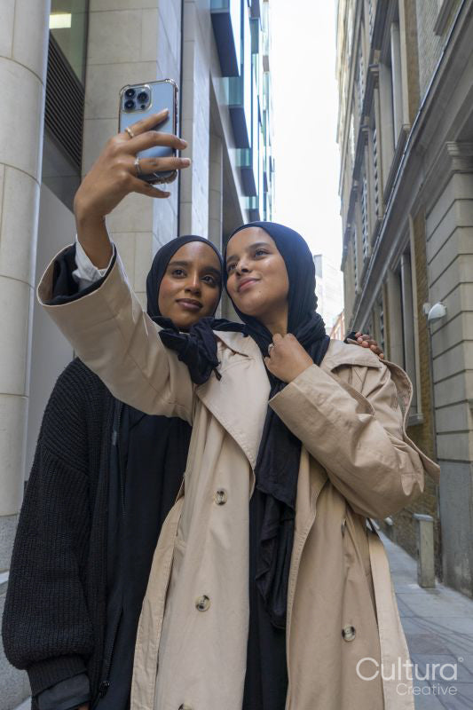 Two young women in city, taking selfie on phone