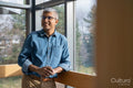 Smiling mature businessman looking through office window