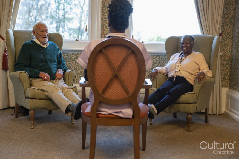 Smiling senior people exercising with nurse in nursing home
