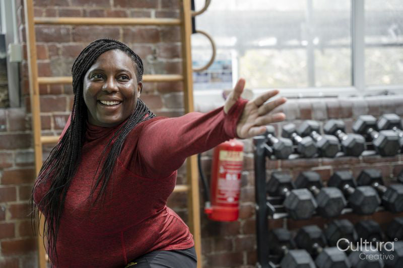 Smiling woman practicing yoga in gym