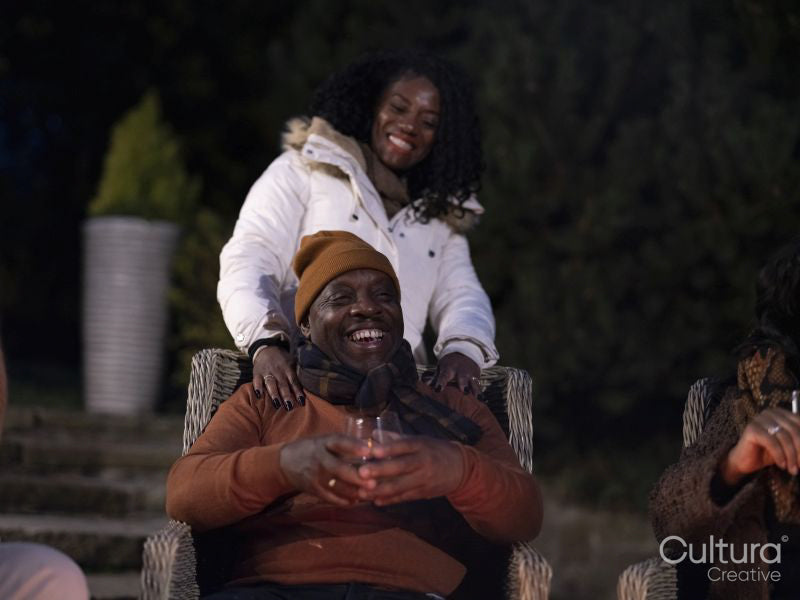 Smiling mature couple relaxing on patio at night