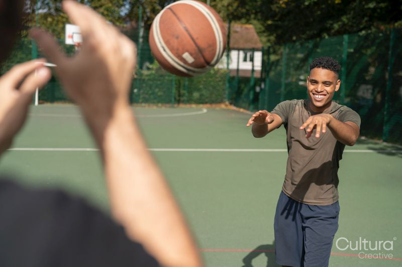 Men playing basketball outdoors