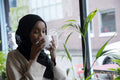Young woman in hijab drinking coffee in cafe