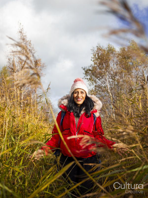 Smiling female hiker walking through tall grass