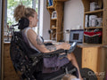 Woman in electric wheelchair working on laptop