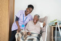 Caregiver and senior woman watching TV and laughing