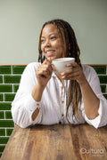 Smiling woman with cup of coffee at cafe table