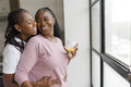 Portrait of happy couple looking through window at home