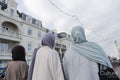 Rear view of three Muslim women walking in city