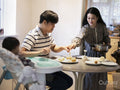 Parents with baby son making moon cakes at home