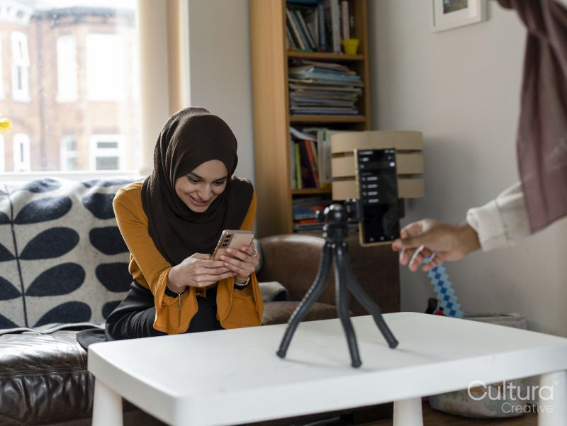 Woman adjusting smart phone on tripod