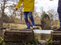 Father with son on stepping stones on lake, low section