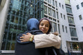 Two women wearing hijabs hugging in street