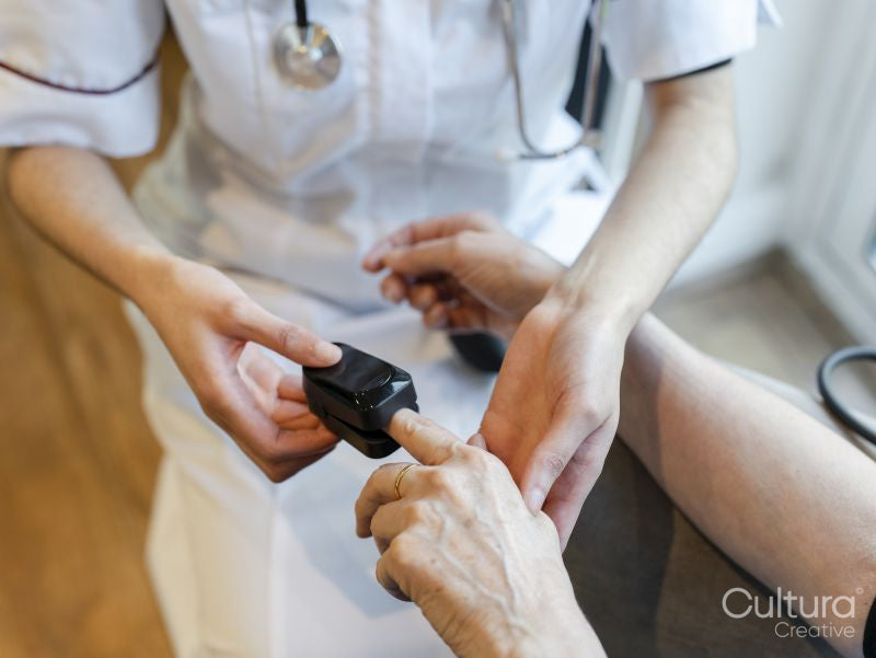 Doctor putting pulse oximeter on patients finger