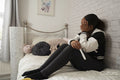 Girl sitting on bed with pregnancy test