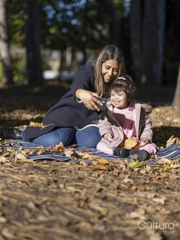 Mother and daughter with Down syndrome taking selfie in park