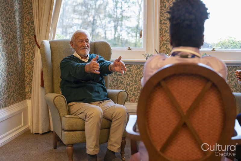 Smiling senior man exercising with nurse in nursing home