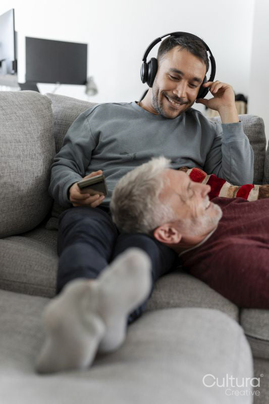 Smiling male couple relaxing on sofa at home