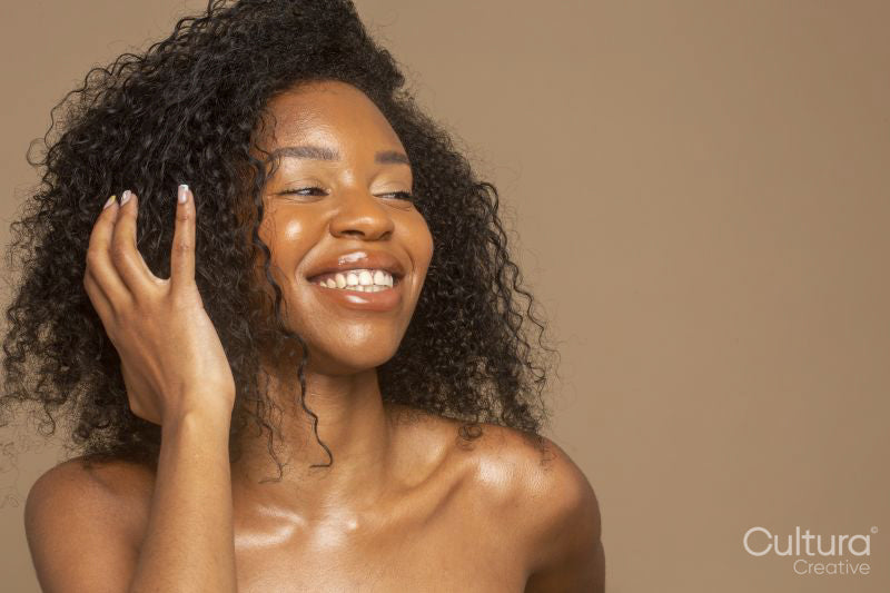 Studio shot of smiling woman with curly hair