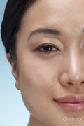 Close-up of woman's face against blue background