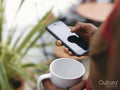 Close-up of mans hands holding smart phone and mug