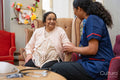 Nursing assistant using pulse oximeter on senior woman at nursing home
