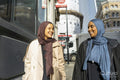 Two young women walking in street