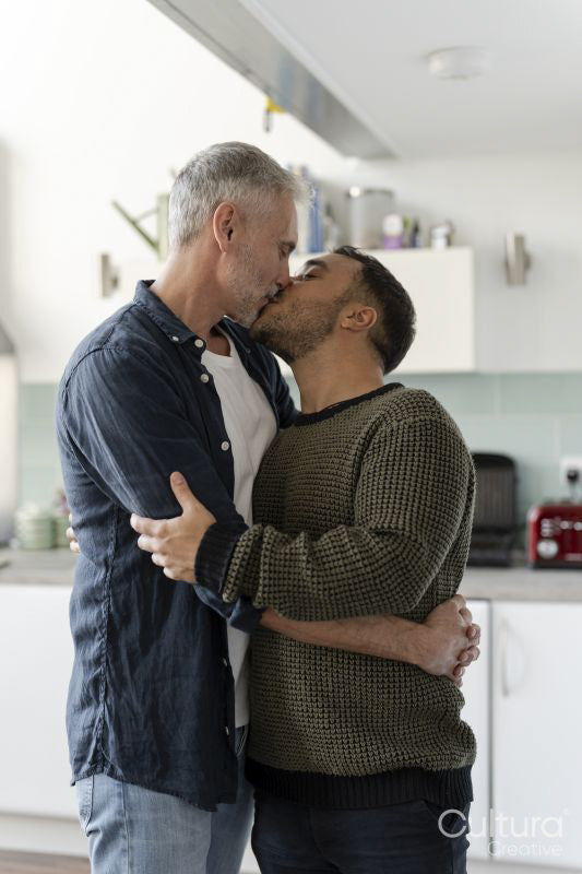 Male couple hugging and kissing at home
