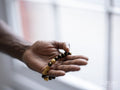 Close-up of hand holding prayer beads