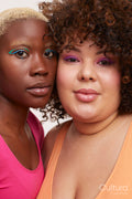 Portrait of two young women wearing make up, cheek to cheek