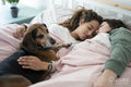 Two women and dog in bed