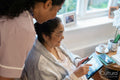 Senior lady showing photography to nurse at nursing home