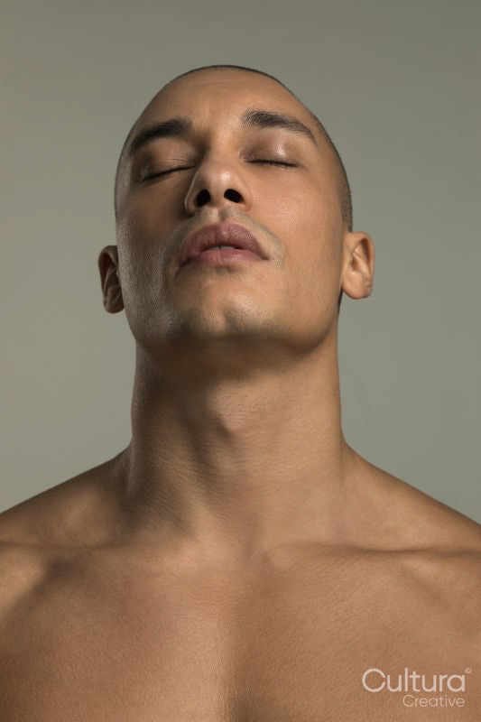 Studio portrait of shirtless man with eyes closed