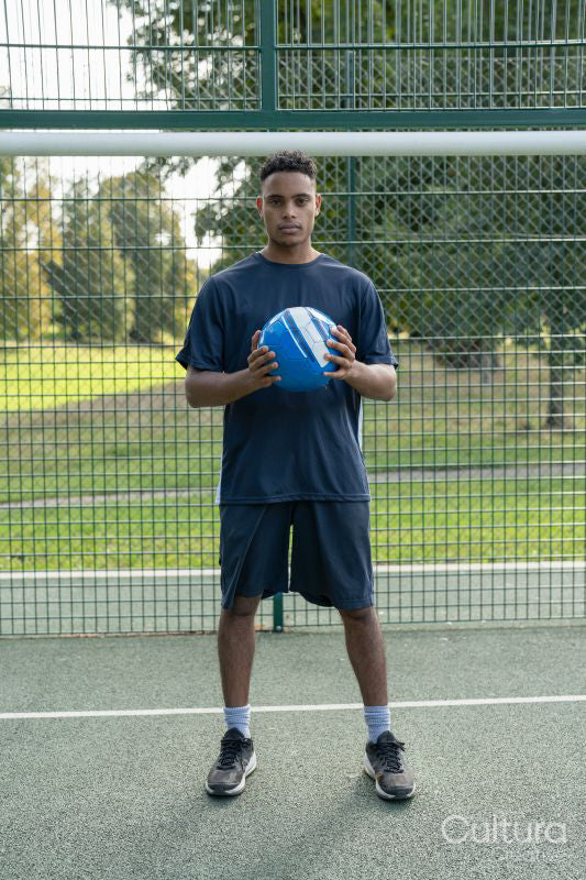 Portrait of man standing with soccer ball outdoors