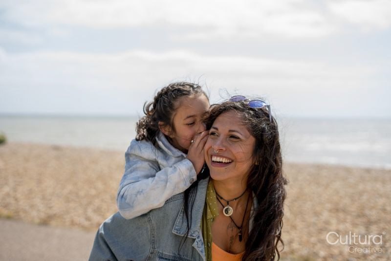 Smiling mother giving daughter piggyback ride