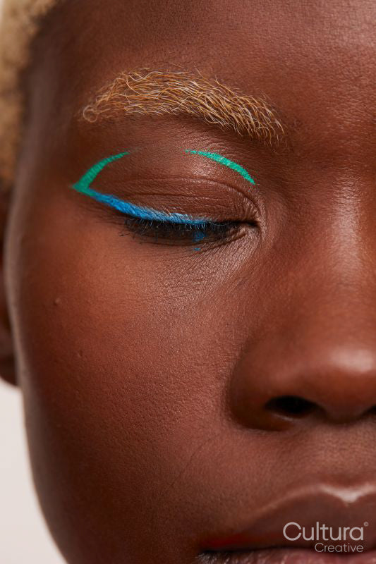 Woman with blue and green make up, eyes closed