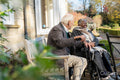 Smiling senior people relaxing on bench in park