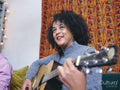 Woman playing acoustic guitar at home