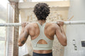 Woman performing chin-up exercise next to climbing wall